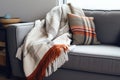 small sofa with a blanket folded in the middle