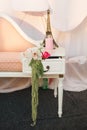 A small sofa in peach color, on which stands a souvenir of the Eiffel tower, a pink candle and a floral arrangement with orchids Royalty Free Stock Photo