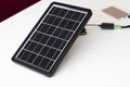 A small solar panel on a white background charges a paverbank Royalty Free Stock Photo