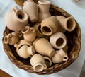 Small souvenir clay pots in a wicker basket