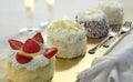 Small sponge cakes decorated with cream, whipped cream and strawberries Royalty Free Stock Photo