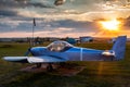 A small sports aircraft parked at the airfield at picturesque sunset Royalty Free Stock Photo