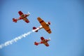 Small squadron of aerobatics airplanes performing tricks in formation with smoke trails