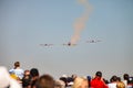 Small squadron of aerobatics airplanes performing tricks in formation with smoke trails