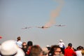 Small squadron of aerobatics airplanes performing tricks in formation with smoke trails