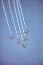 Small squadron of aerobatics airplanes performing tricks in formation with smoke trails