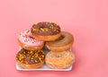 Small square plate with donuts stacked, pink background Royalty Free Stock Photo