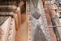 A small squirrel jumping up on a decorated temple wall