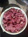 A small stack of pieces of beef in a container or basin