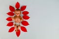 Small statue of Infant Jesus on red leaves of poinsettia plant, Christmas concept Royalty Free Stock Photo