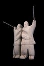 Small statue of Inuit hunter with a spear made of animal bone. Isolated on black background. Inuit art. Tribal culture