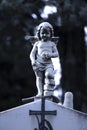 Small statue of a little angel at the gravestone at the old cemetery in Dalmatia, close up on moonlight Royalty Free Stock Photo