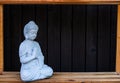 A small statue of buddah with wood background Royalty Free Stock Photo