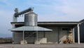 Small steel granary silo with conveyor belt in an agricultural building