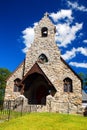 A small stone church sits on a humble lot