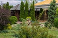 A small stone fountain in a beautiful greened courtyard near a wooden house Royalty Free Stock Photo