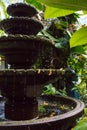 Small stone fountain in tropical garden. Fountain in vase in asian backyard. Zen and peace concept. Royalty Free Stock Photo