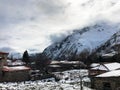 Small stone houses, buildings in the village on a beautiful mountain cold winter resort with high mountain peaks mist and snow Royalty Free Stock Photo