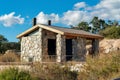 Small stone outhouse or bathroom with tin roof and chimney vent pipes in national park or outdoor area for travelers Royalty Free Stock Photo