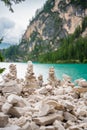 Small stone pyramides near alpine lake Braies or Pragser Wildsee, Dolomites Alps, Italy. Royalty Free Stock Photo