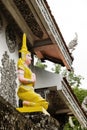 Small stone yellow statue Buddha near to temple. Royalty Free Stock Photo
