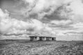 Small stony empty houses on grass and cloudy sky