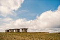 Small stony empty houses on green grass and cloudy sky