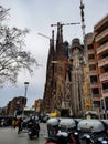 A small street with trash cans next to the la sagrada de familia in Barcelona under construction with cranes Barcelona