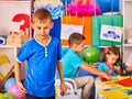 Small students boy painting in art school class.