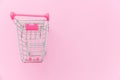 Small supermarket grocery toy push cart isolated on pink pastel colorful background Royalty Free Stock Photo