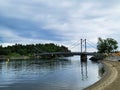 Small suspension bridge over the lake on a cloudy day