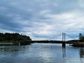 Small suspension bridge over the lake on a cloudy day