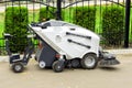 Small sweeper machine standing at parking storage after cleaning city park alley.Sweeping vacuum cleaner vehicle removing dust and Royalty Free Stock Photo