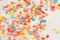 Small sweet various colourful candies on a holographic background. Minimalist pastel abstract