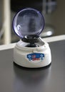 Small table centrifuge in chemical laboratory. Closeup table medical centrifuge. Researcher separates supernatant and pellets by