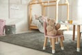 Small table, chair with bunny ears and teddy bear in children`s bedroom Royalty Free Stock Photo