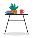 A small table with a stack of books, potted plant and a cup of coffee or tea. Cozy workplace