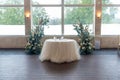 Small table with tulle and two floral compositions in the wedding hall