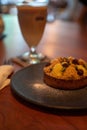 Small tart on the palte, with cream, nuts and raisins on it