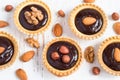 small Tarts with chocolate and different nuts on a white background, top view, closeup Royalty Free Stock Photo