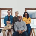 We are a small team but we work hard. Portrait of a group of confident businesspeople seated together inside of the Royalty Free Stock Photo