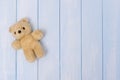 Small teddy bear on blue pastel wooden background, top view Royalty Free Stock Photo
