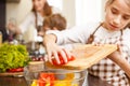 Small teenage girl cutting tomatoes in salad Royalty Free Stock Photo