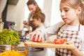 Small teenage girl cutting tomatoes in salad Royalty Free Stock Photo