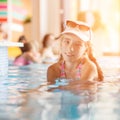 Small teenage girl in hotel resort pool near a bar Royalty Free Stock Photo