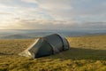 Small Tent Pitched On Hill In Lake District With Green Summer Grass.