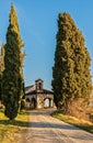 Small 13th century rural church with cypresses. Royalty Free Stock Photo