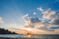 A small Thai passenger ship at dawn in tannot Bay. The sun rises on the sea. The ship sways on the waves