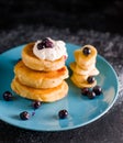 Small thick pancake with berries and sour cream on a beautiful blue plate home cooking tomorrow with goodies