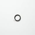 A small, tightly coiled black wire is placed at the center of a white surface. The coil is Royalty Free Stock Photo